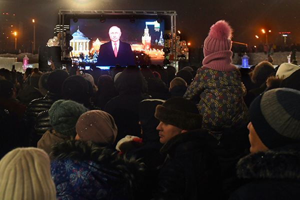 Горожане слушают обращение президента Владимира Путина у Центральной елки в Казани.? РИА Новости / Максим Богодвид